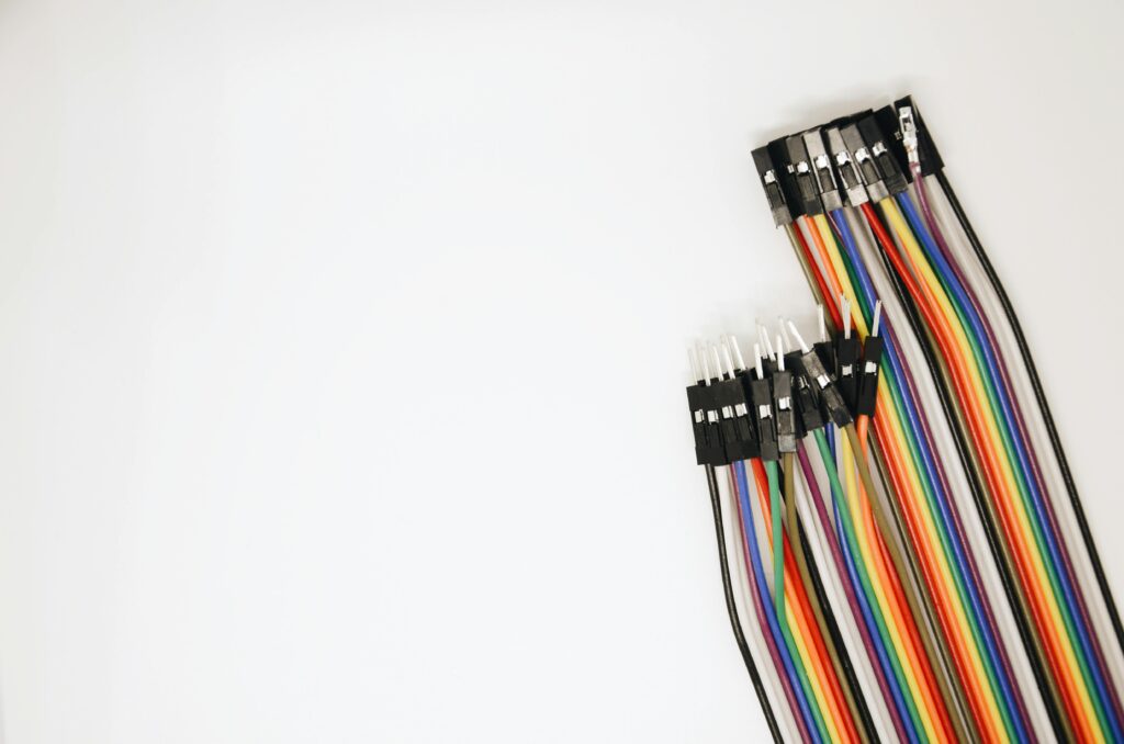 A set of colorful rainbow electrical jumper wires laid out on a white background.